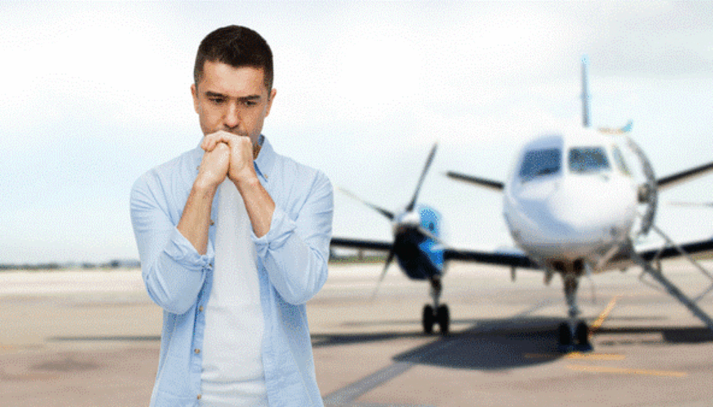 Fearful man standing on tarmac with aircraft in background
