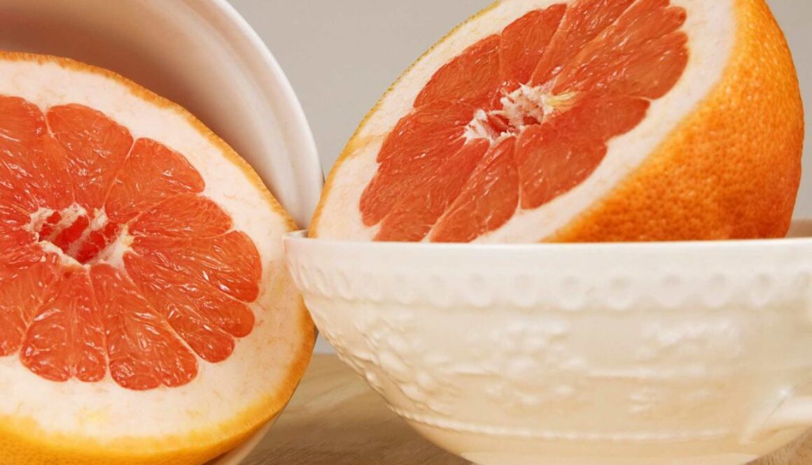 Whole ceramic bowls each containing a half of a grapefruit