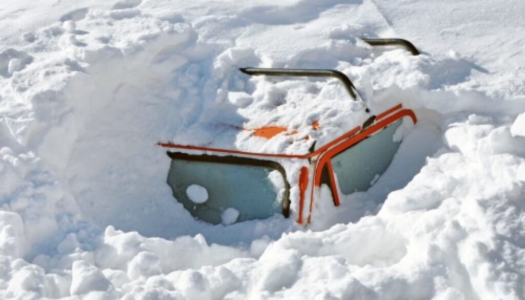 Snow covered car in the winter blizzard