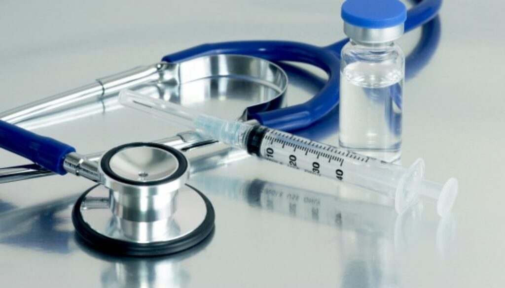 Syringe, vial and stethoscope on surgical tray.