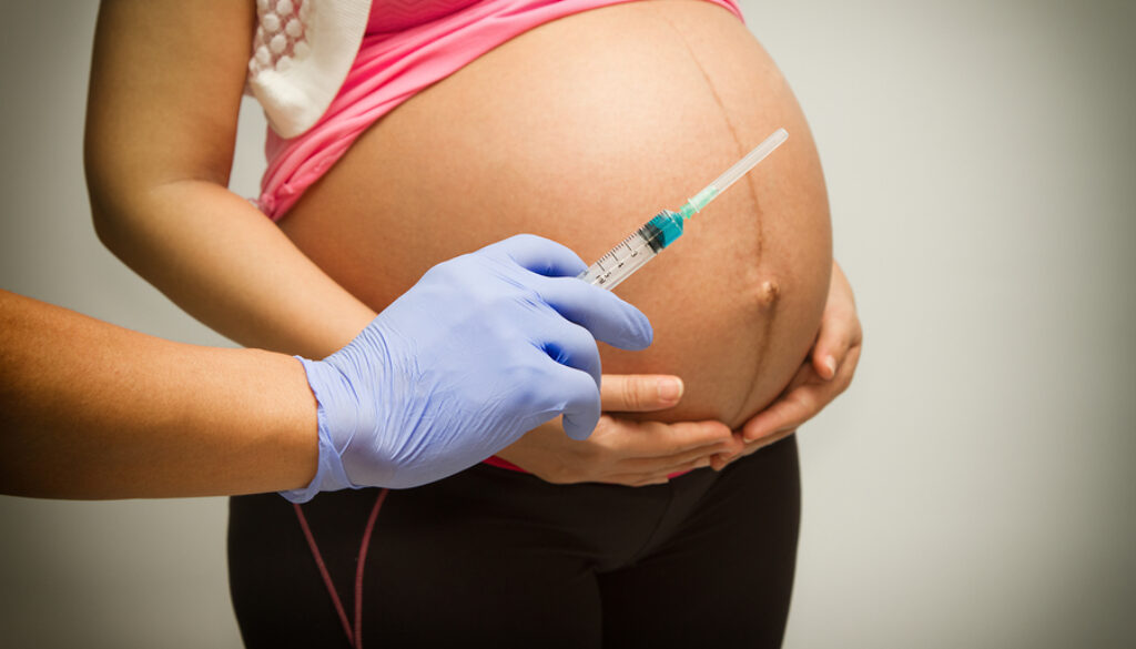 Pregnant Woman With Syringe ,vaccinating A Pregnant Woman