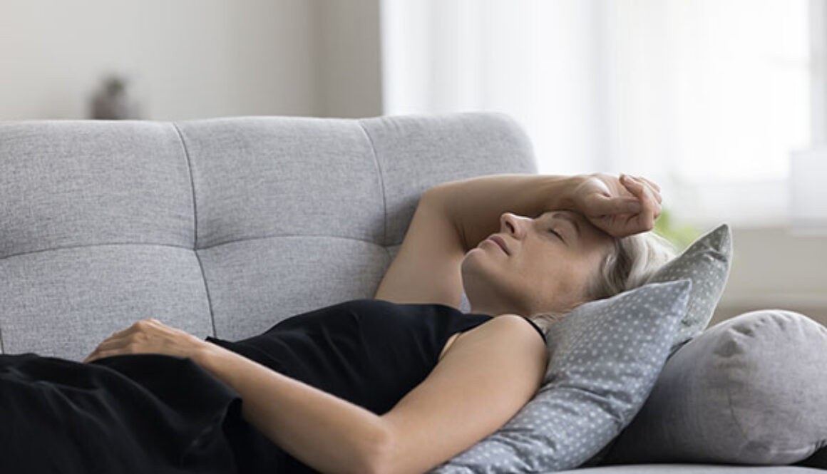 Peaceful woman lying on back on sofa with closed eyes
